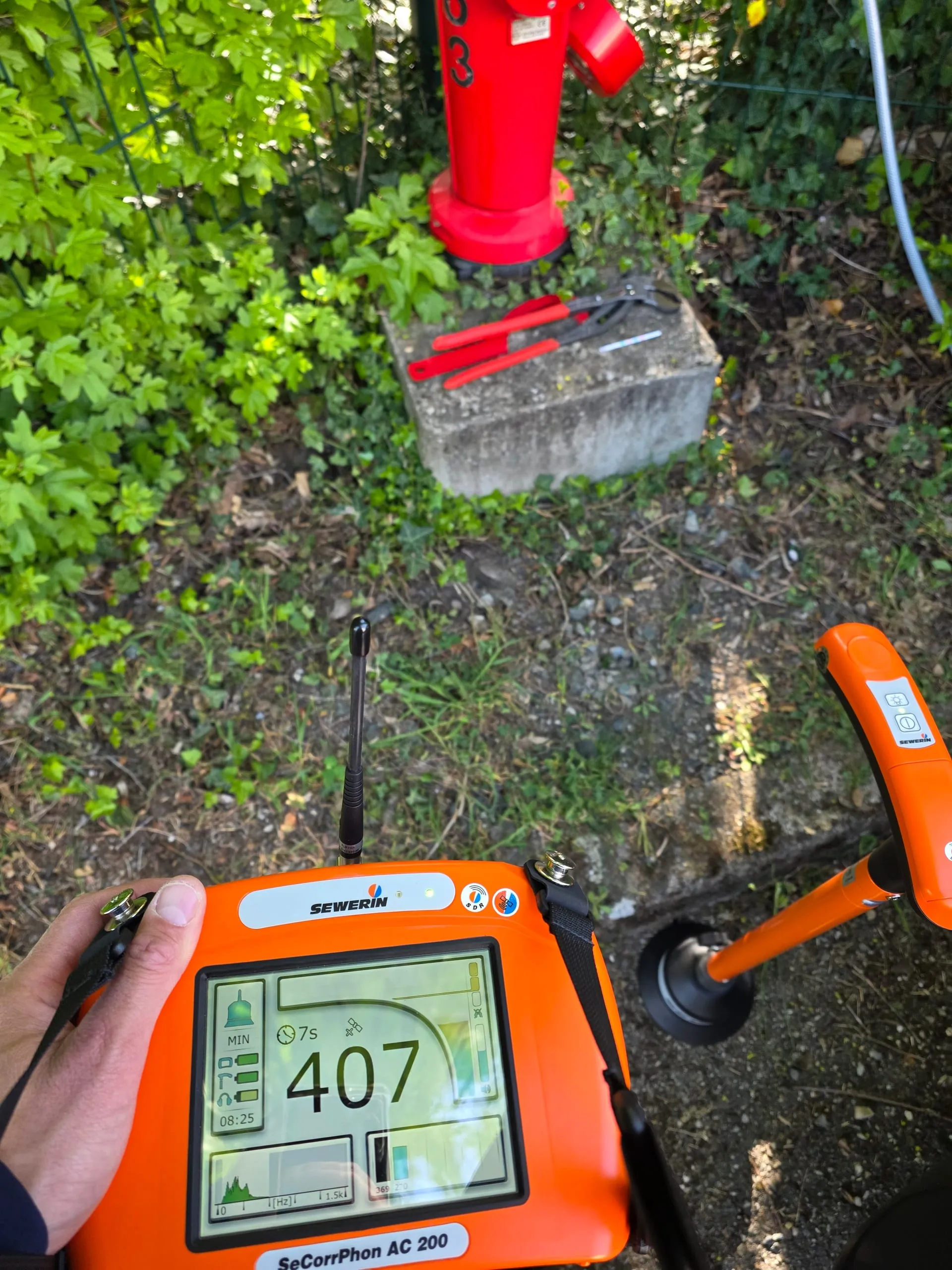 Détecteur acoustique orange utilisé près d’un regard de réseau d’eau extérieur