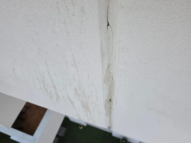 Fissure de façade avec traces d'infiltration