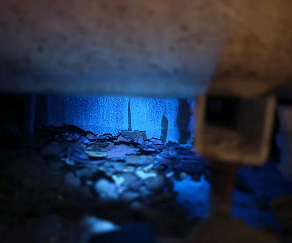 Aiguille de traçage sous un plancher de cave éclairée en lumière UV bleue