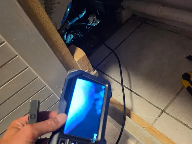 Main tenant une caméra d'inspection endoscopique avec écran bleu allumé, lors d'une intervention sur canalisation par GBL Détection.