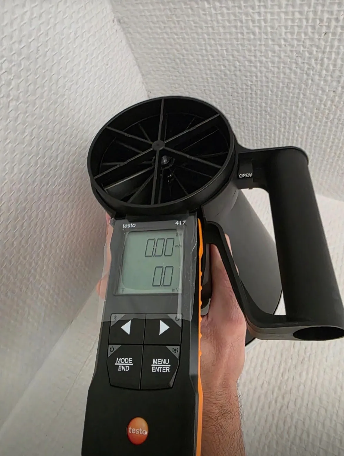 Anémomètre portatif mesurant le débit d’air contre une paroi intérieure
