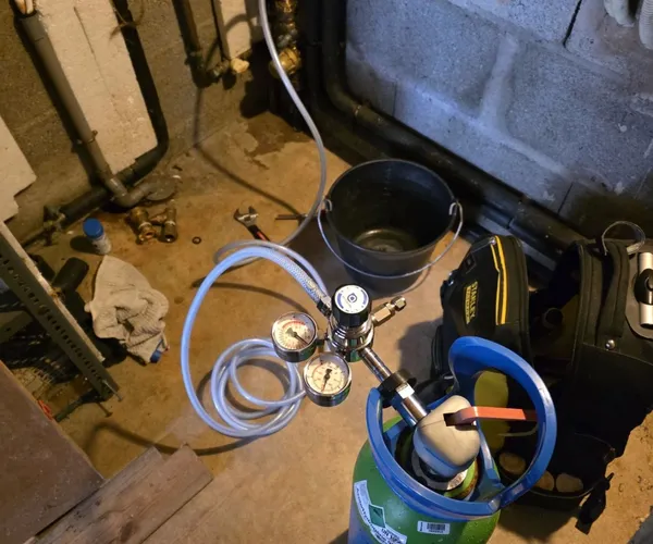 Bouteille de gaz traceur et manomètres raccordés à un réseau dans un local technique